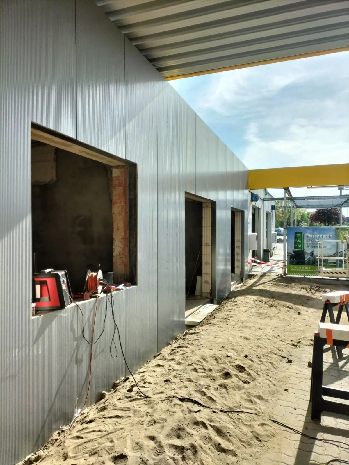 Wandmontage mit vertikalen Sandwichpaneelen an einem Gewerbegebäude
